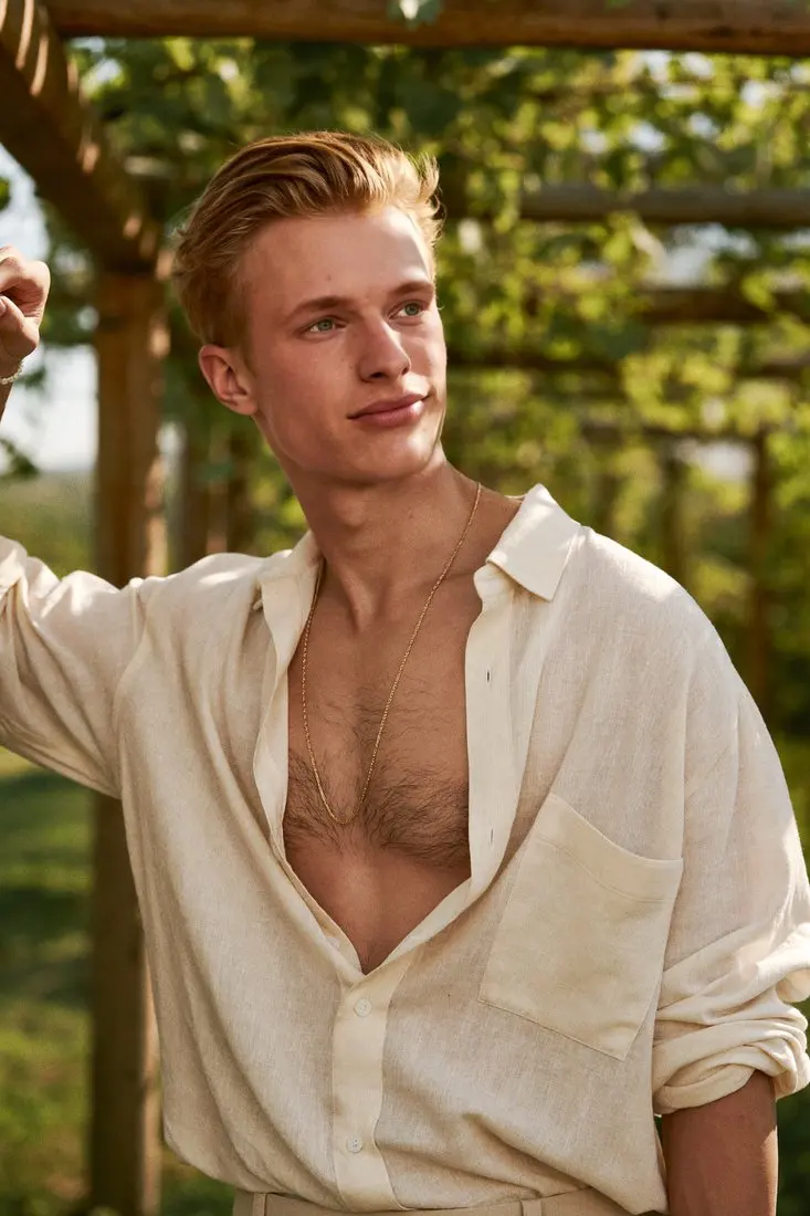 After: same linen shirt and vineyard pergola, face replaced and hair rebuilt, shirt unchanged