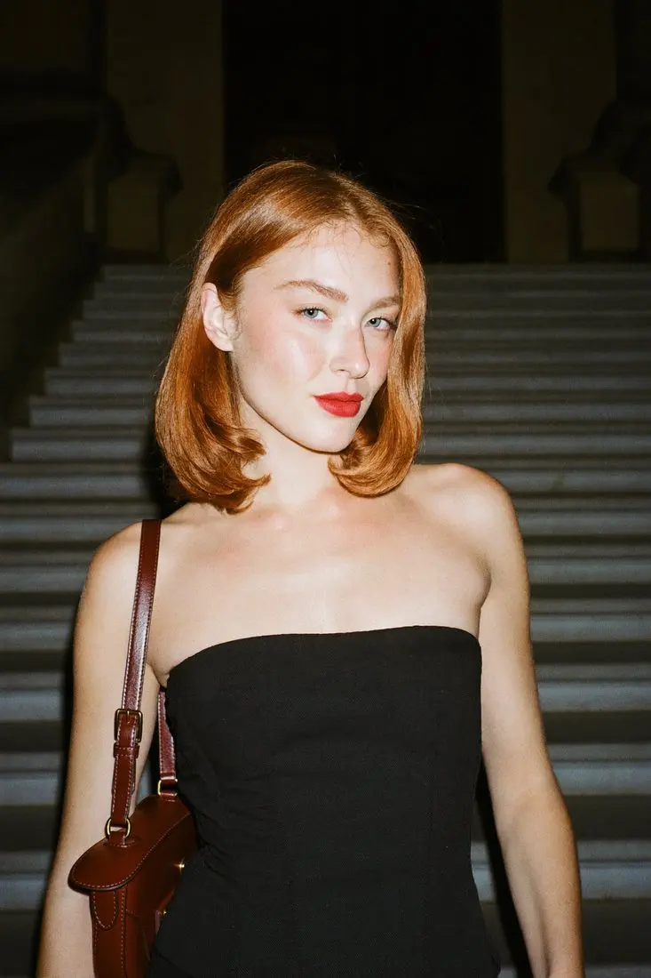 Before: person in a black strapless dress on a dark staircase, face and hair as photographed