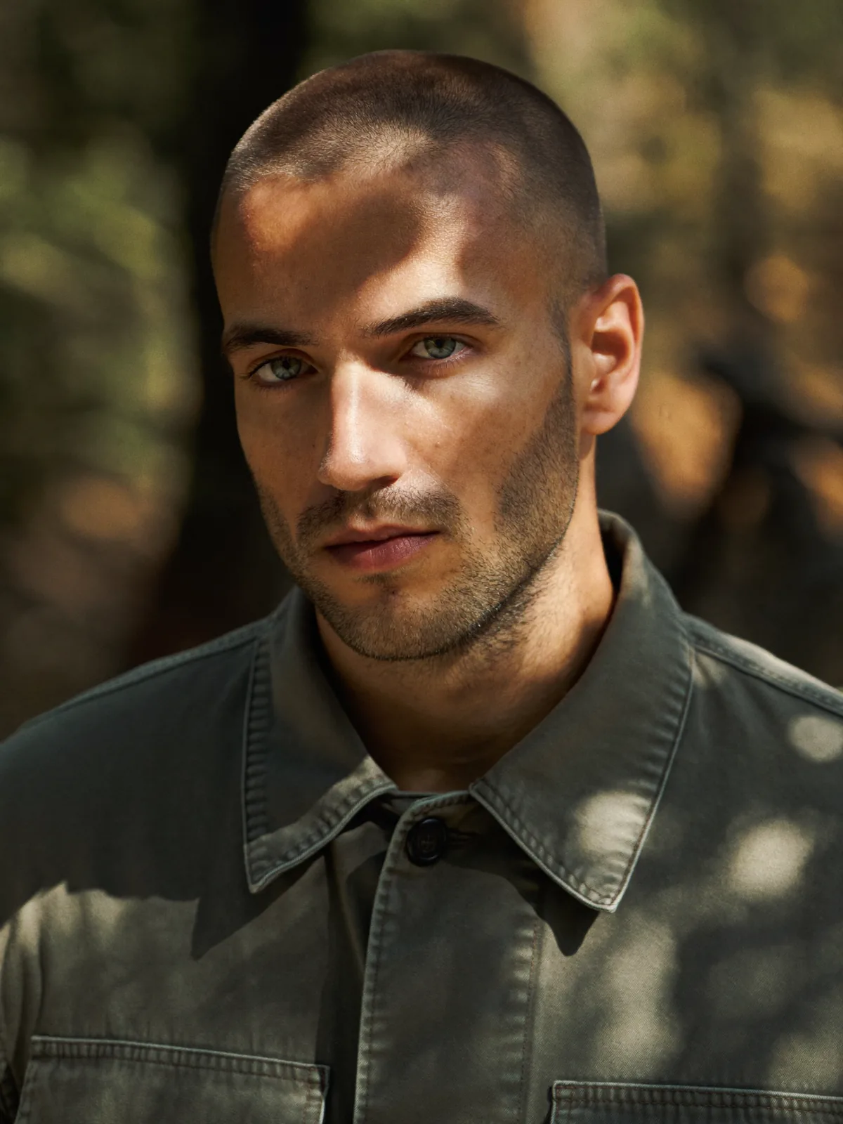Before: man in an olive shirt in dappled forest light