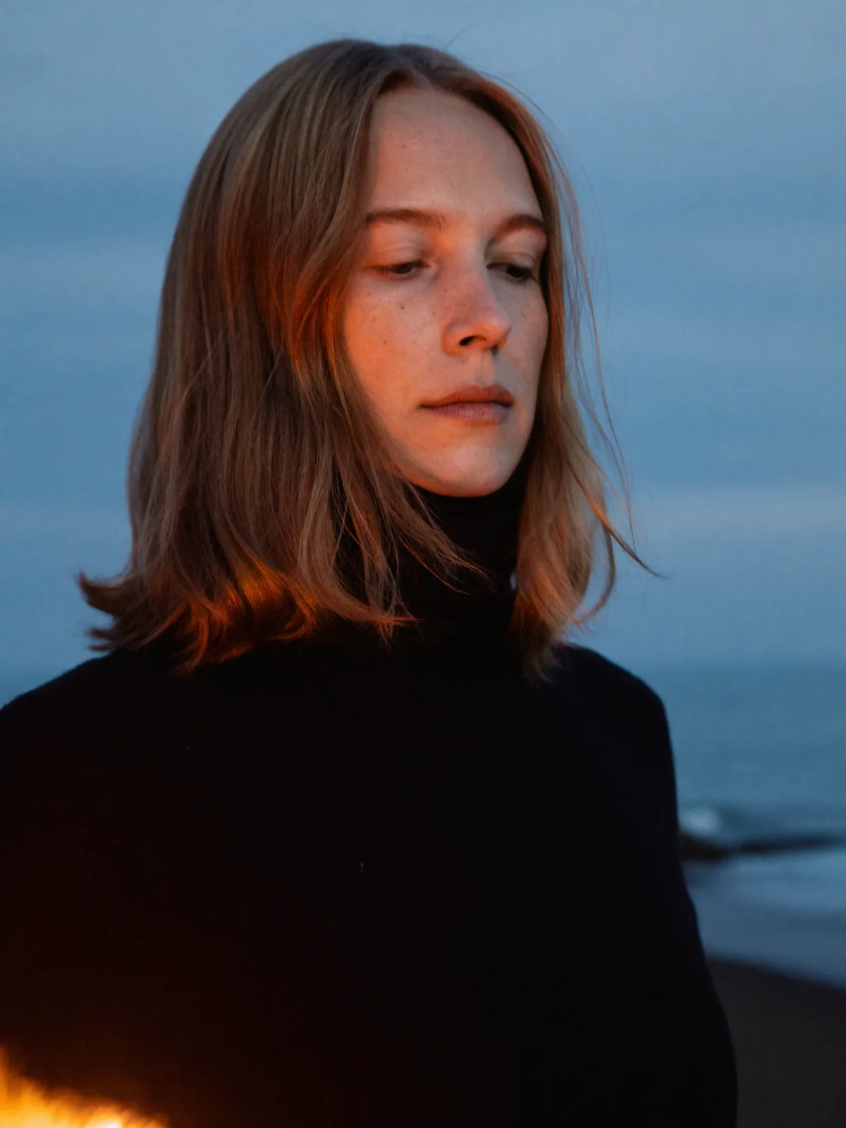 Before: woman in a black turtleneck at blue hour
